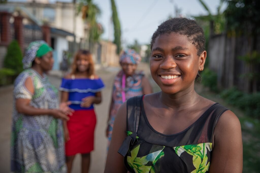 Portrait of a young African girl with other African women of different ages behind her